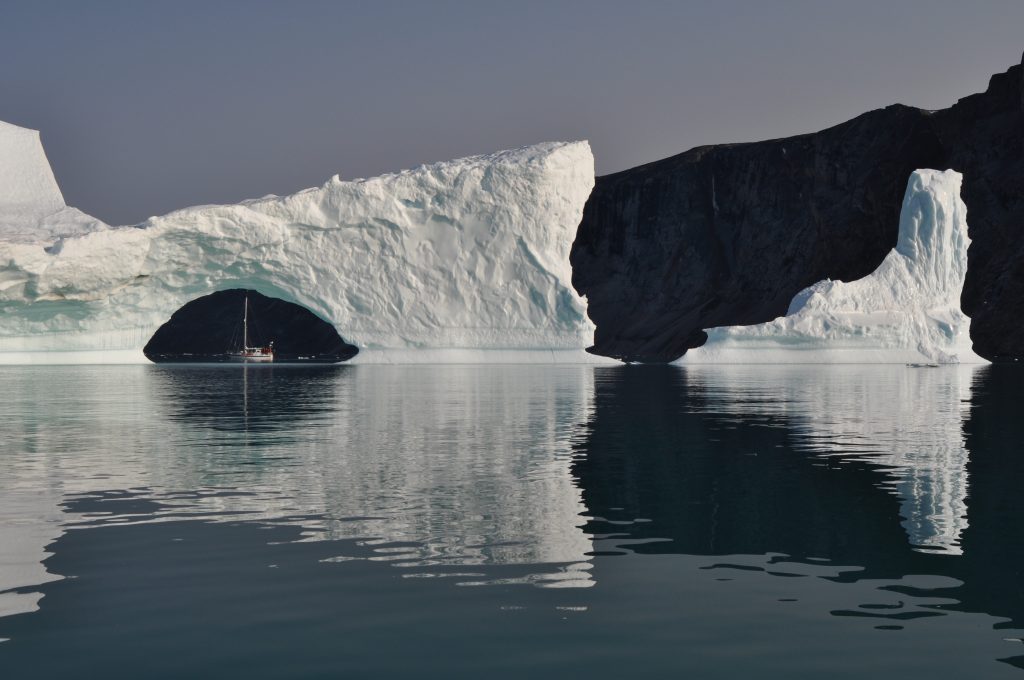 Boat tucked in a cave below an ice shelf